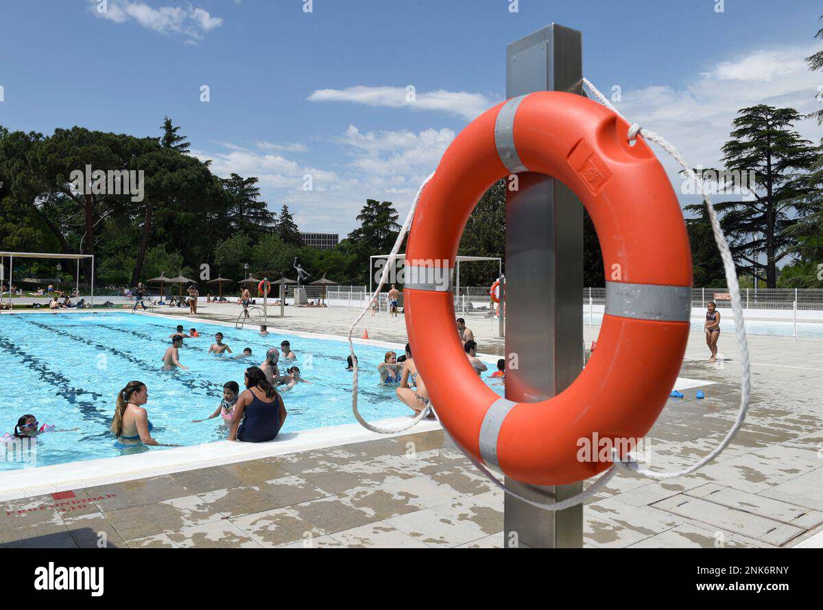 Several people bathe and sunbathe at the municipal swimming pool in