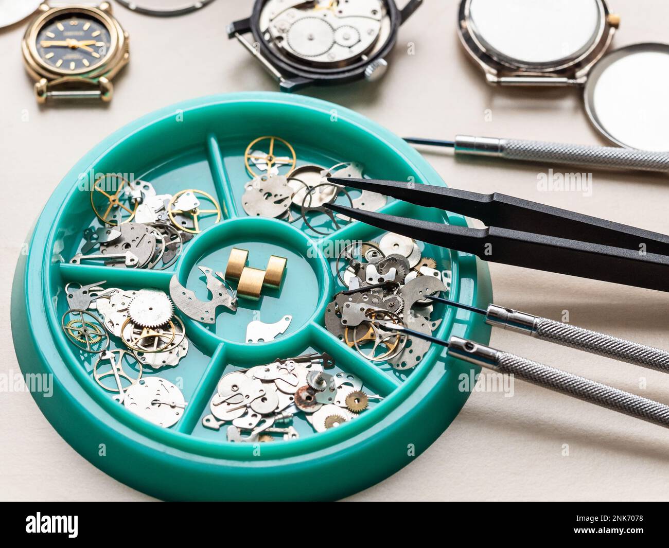 clock spare parts in tray on wooden table in watchmaker workshop Stock Photo Alamy