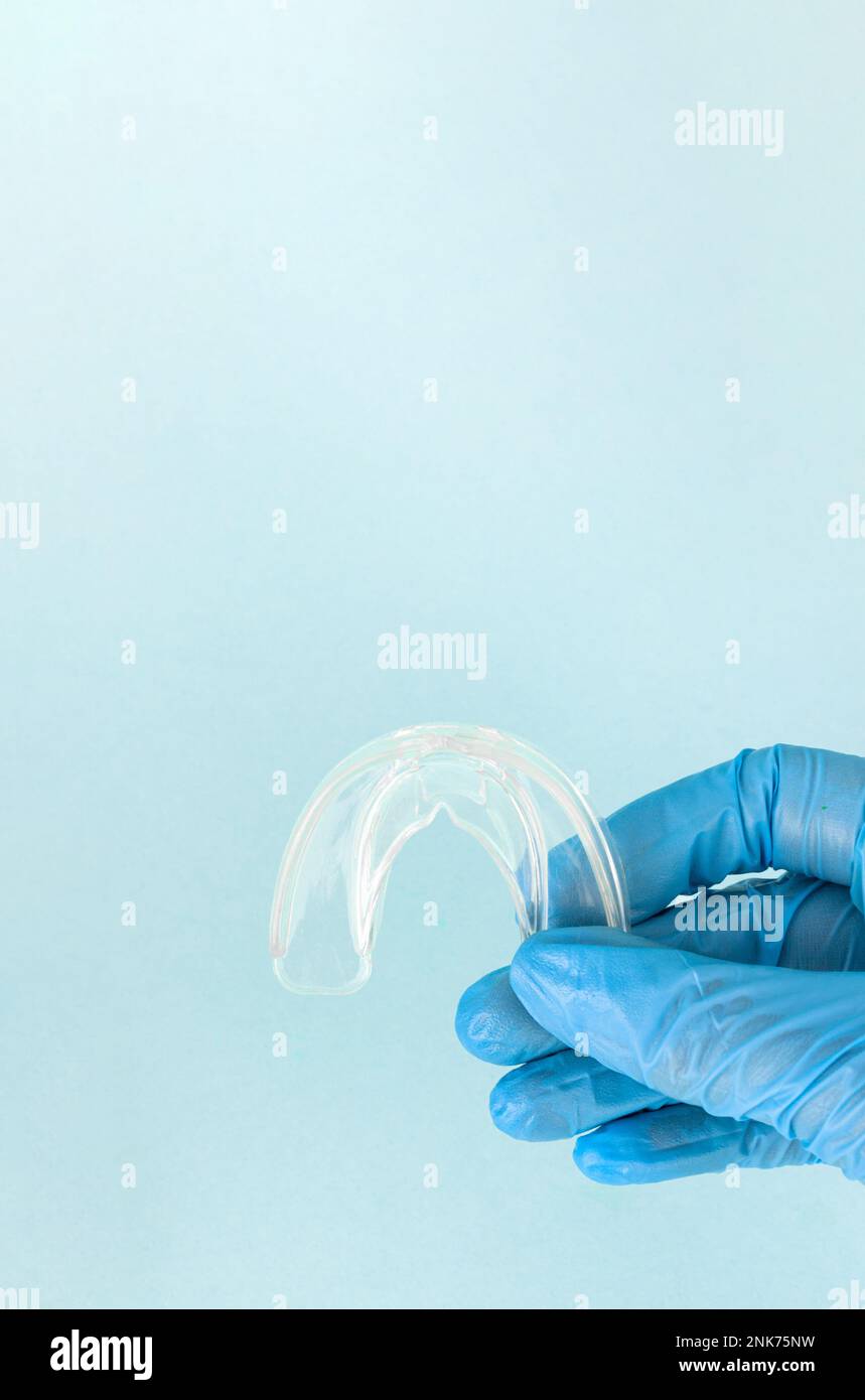 Tooth whitening, a tooth mold in doctors hand. Dental beauty treatment. Teeth retaining tools