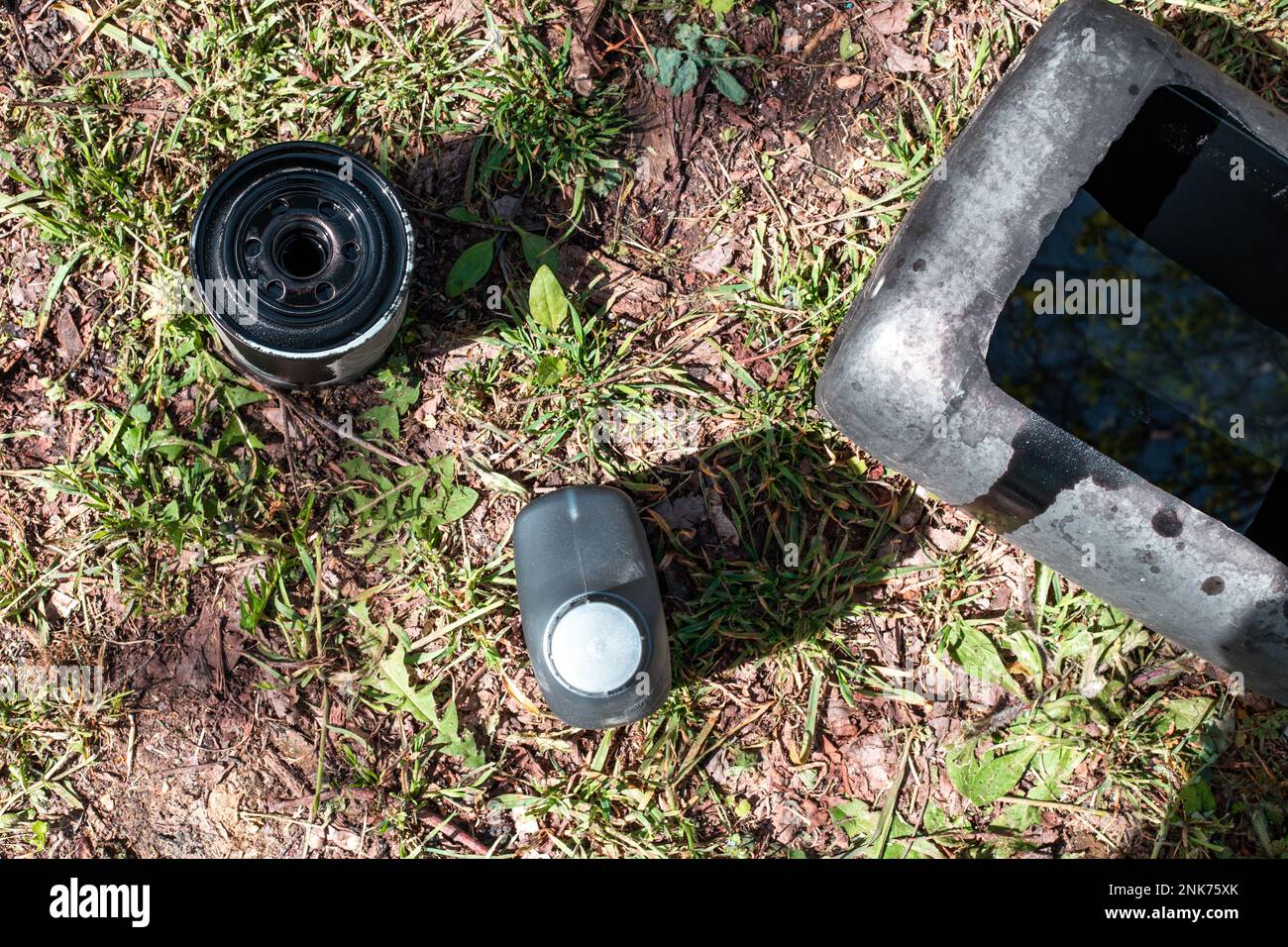 Oil filter and canister with used and new machine oil. Changing the oil