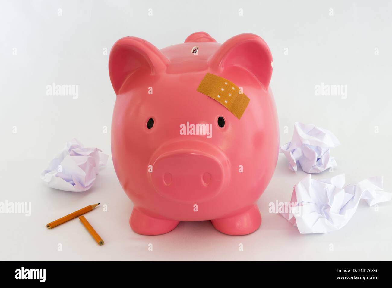 Piggy bank symbol for inflation, economy and crisis. Pink coloured on white background Stock Photo