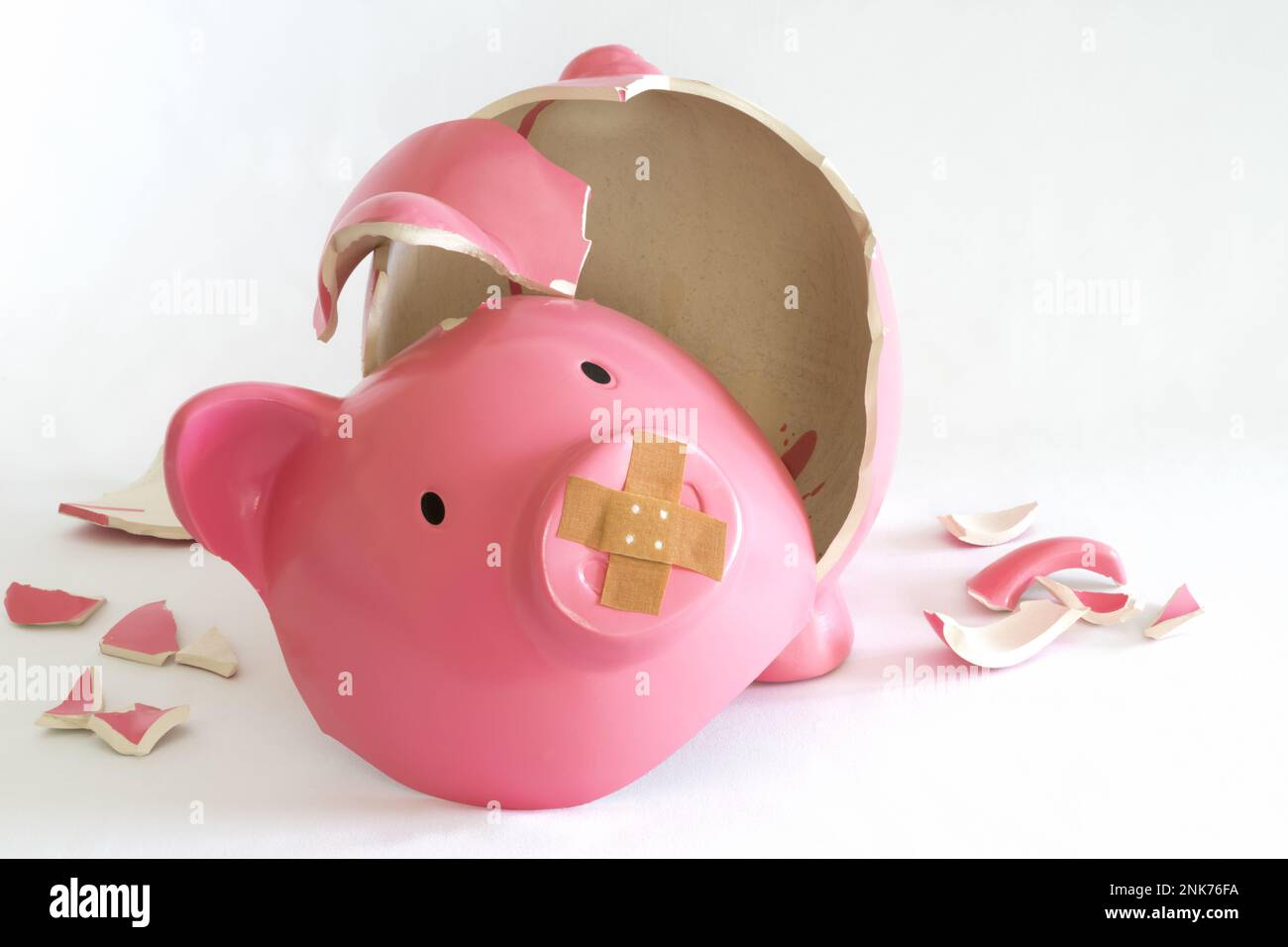Piggy bank symbol for inflation, economy and crisis. Pink coloured on white background Stock Photo