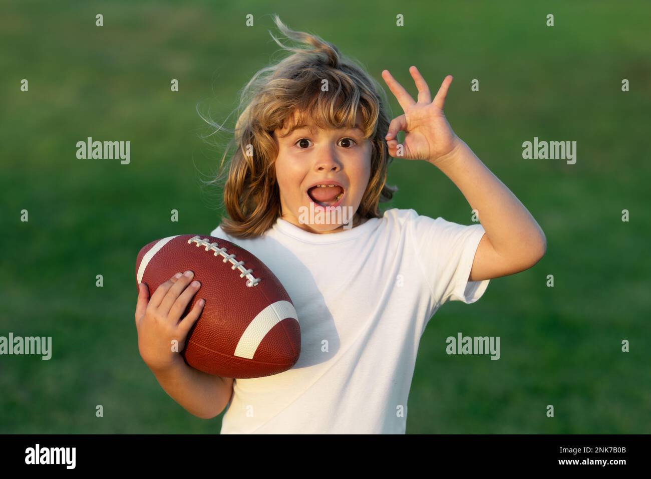 Kids and sports. Young boy playing american football. Kid boy playing