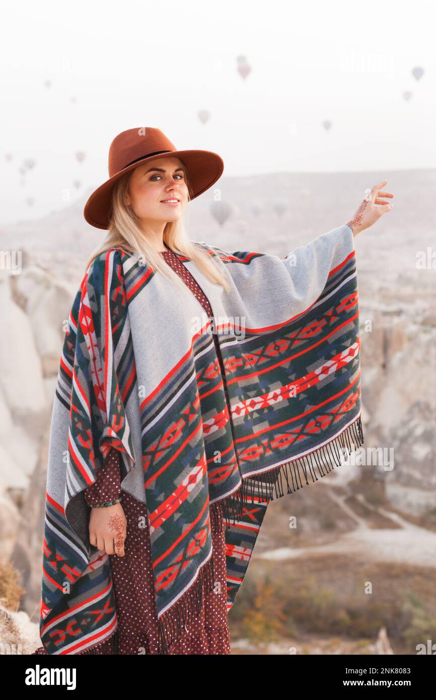 Beautiful traveling woman wearing authentic boho chic style poncho