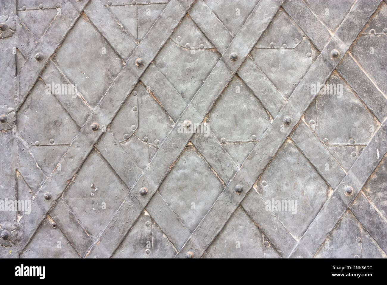 Old metal wrought door of medieval building close up, horizontal grunge background Stock Photo