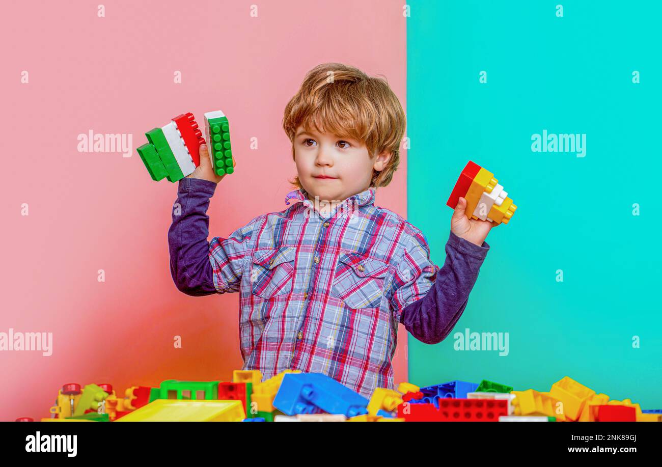 Little boy playing with lots of colorful plastic blocks constructor ...