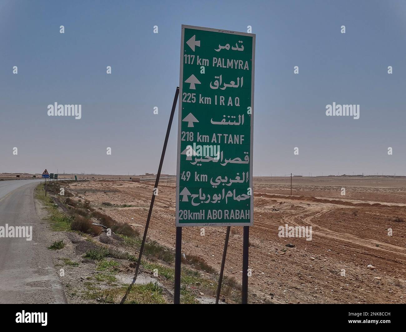 Road sign in the desert of Syria pointing towards Baghdad in Iraq Stock