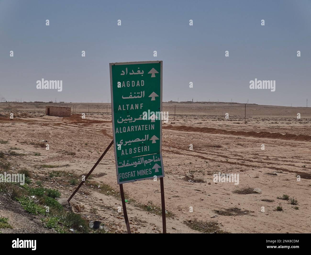 Road sign in the desert of Syria pointing towards Baghdad in Iraq Stock