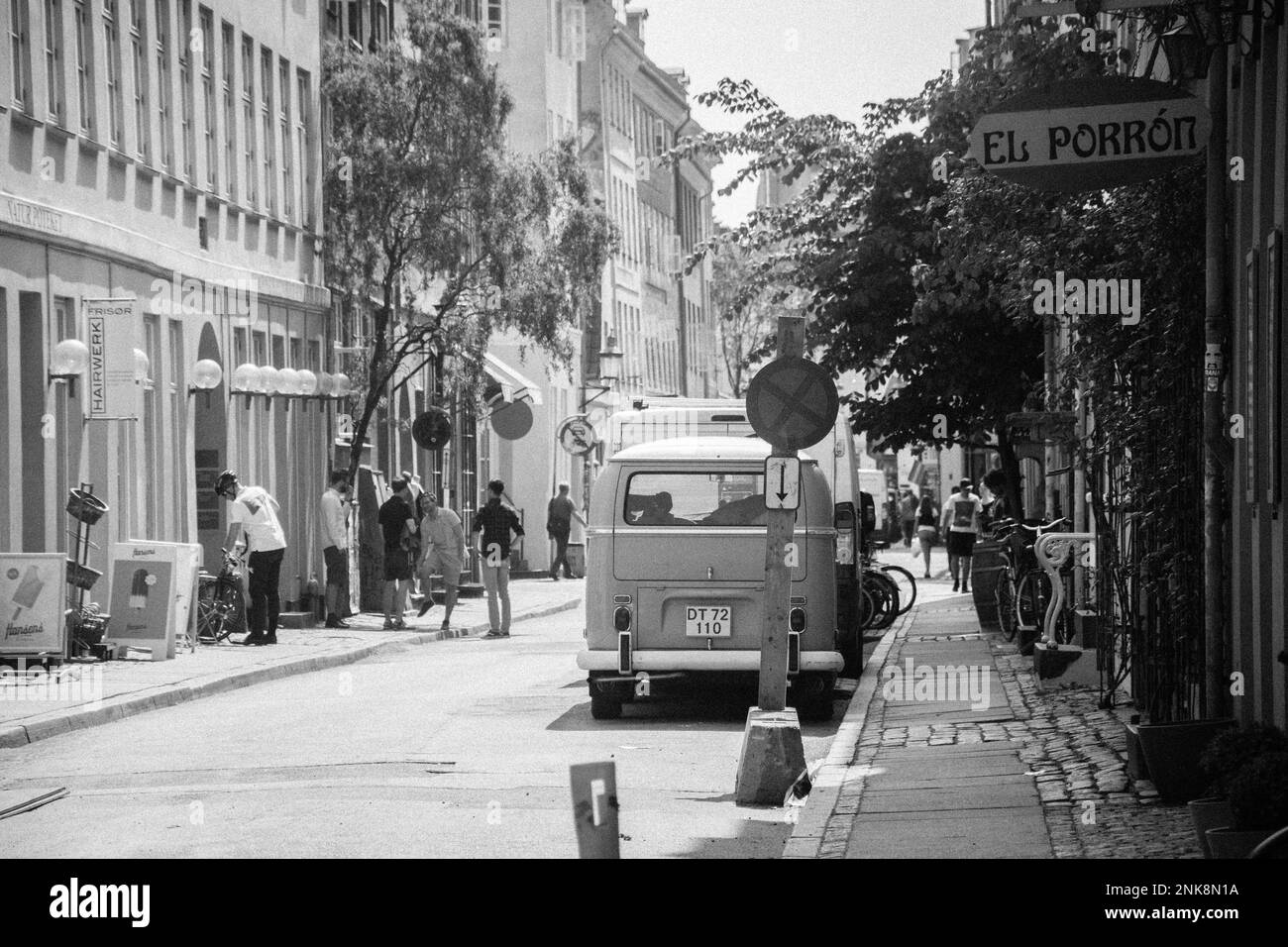 A french street in france with an old time car parked by the sidewalk
