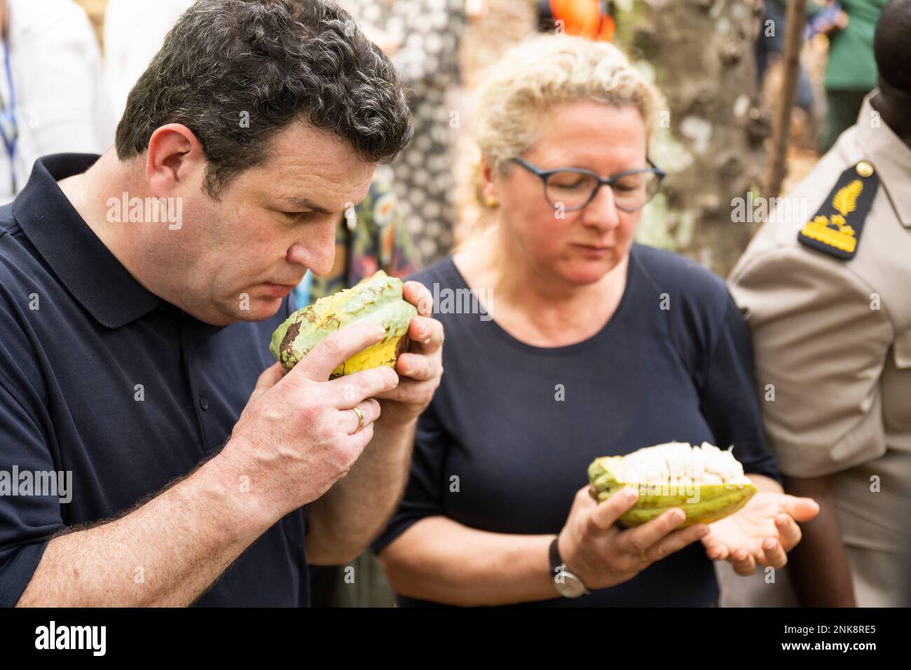 Agboville, Ivory Coast. 23rd Feb, 2023. Hubertus Heil (SPD), Federal Minister of Labor and Social Affairs, and Svenja Schulze (SPD), Federal Minister for Economic Cooperation and Development, smell opened cocoa pods at a cocoa plantation. Federal Minister of Labor Heil and Federal Minister for Economic Cooperation and Development Schulze visit Ghana and Côte d'Ivoire. Credit: Christophe Gateau/dpa/Alamy Live News Stock Photo