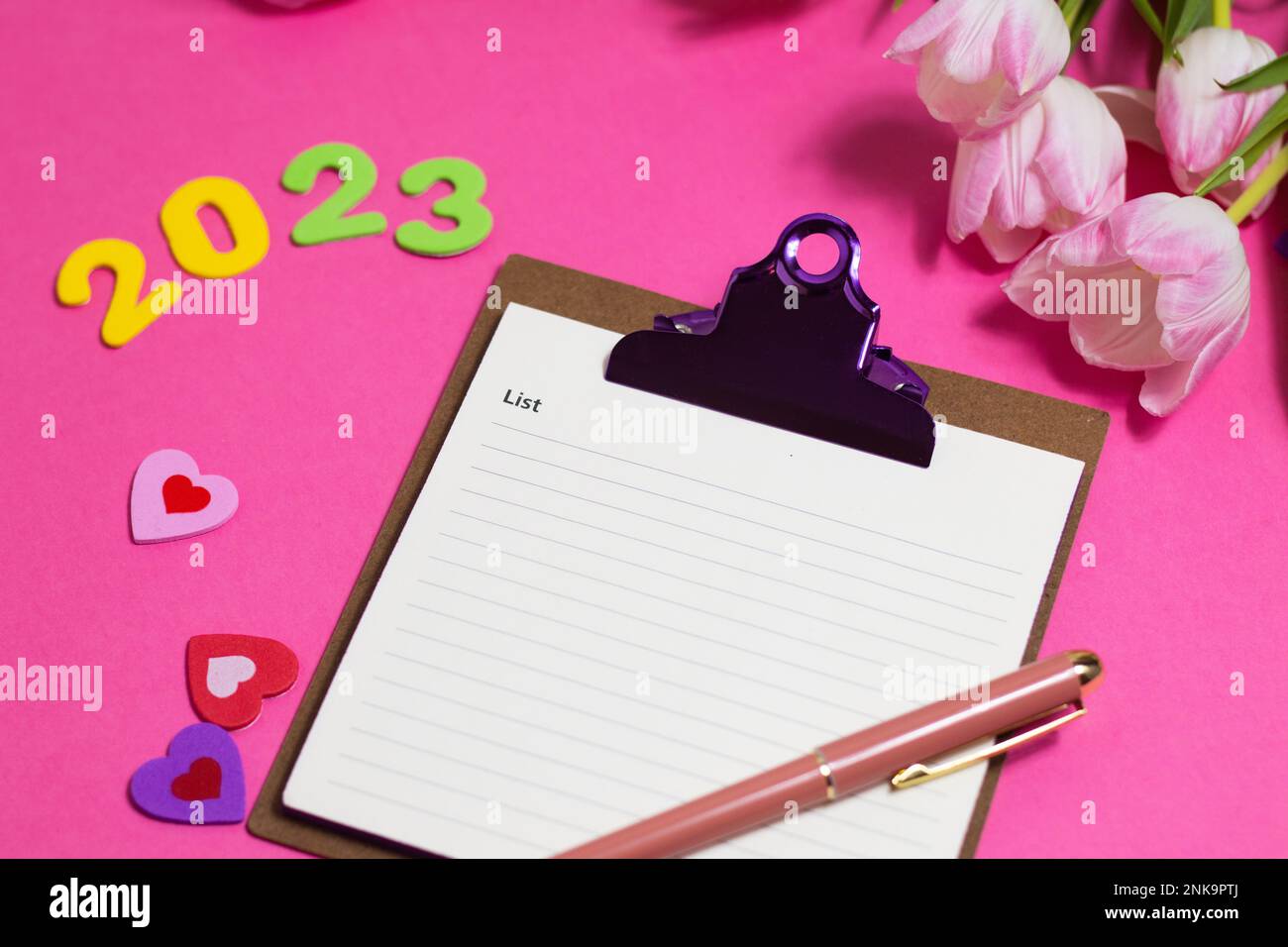 Composition with blank, 2023 and beautiful tulip flowers on pink background Stock Photo