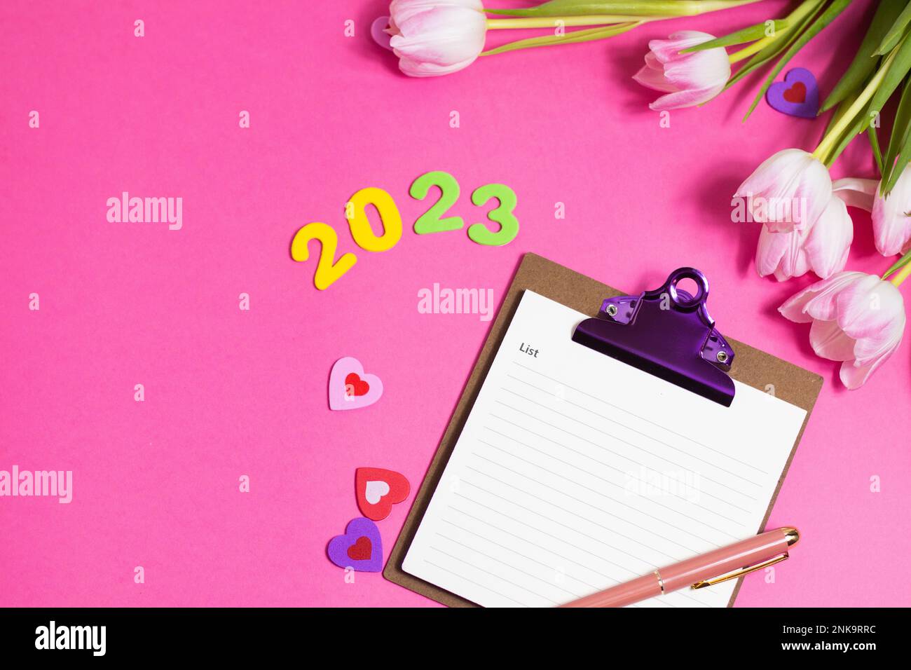 Composition with blank, 2023 and beautiful tulip flowers on pink background Stock Photo