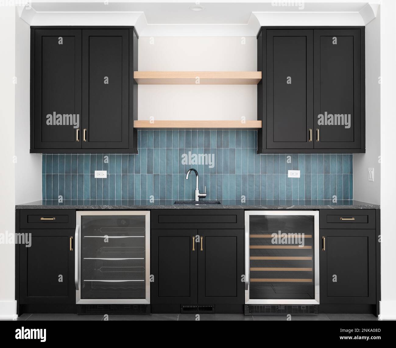 A wet bar with black blue vertical subway tile backsplash