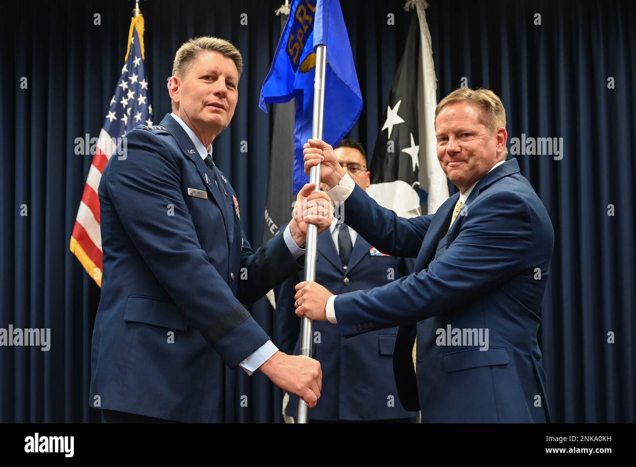 U.S. Space Force Gen. David D. Thompson, Vice Chief of Space Operations (left), presents the guidon to Dr. Kelly Hammett (right), Space Rapid Capabilities Office director and program executive officer, during an assumption of leadership ceremony at Kirtland Air Force Base, N.M., Aug. 12, 2022. The Space RCO's primary mission is to develop and deliver critical space capabilities for the U.S. Space Force. Stock Photo
