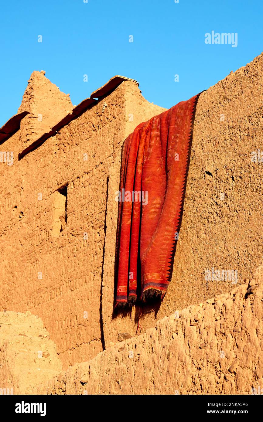 Drying carpet on the earthen walls of the house, Morocco Stock Photo