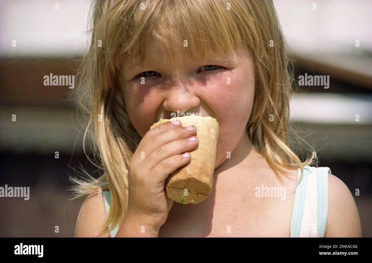 Solonetu Nou, Suceava County, Romania, 2001. Young girl on the village road eating a waffle ice-cream. Stock Photo