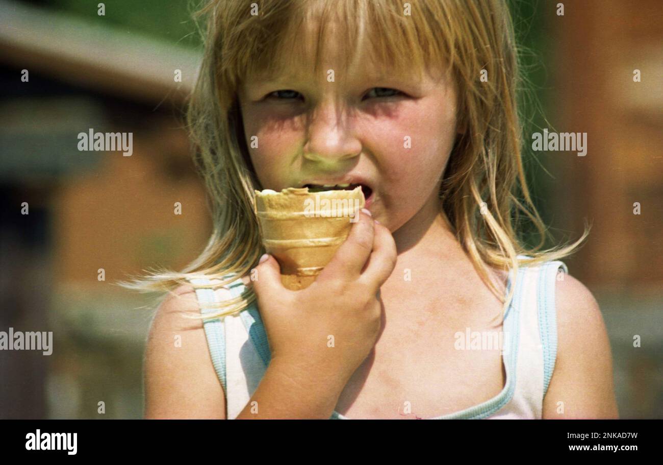 Solonetu Nou, Suceava County, Romania, 2001. Young girl on the village road eating a waffle ice-cream. Stock Photo