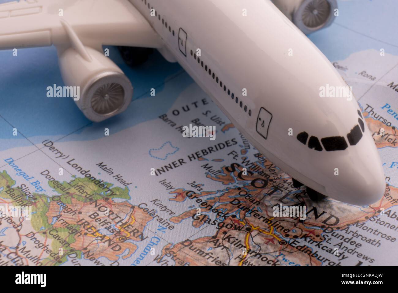 Close up of colorful map with miniature plane highlighting Glasgow, Scotland through selective focus, shallow depth of field, background blur Stock Photo