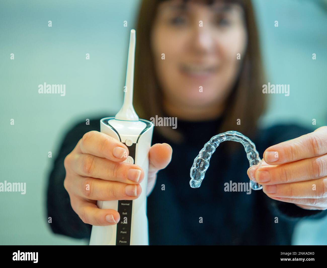 Maintaining a healthy smile a young woman performs her dental hygiene routine at home using a