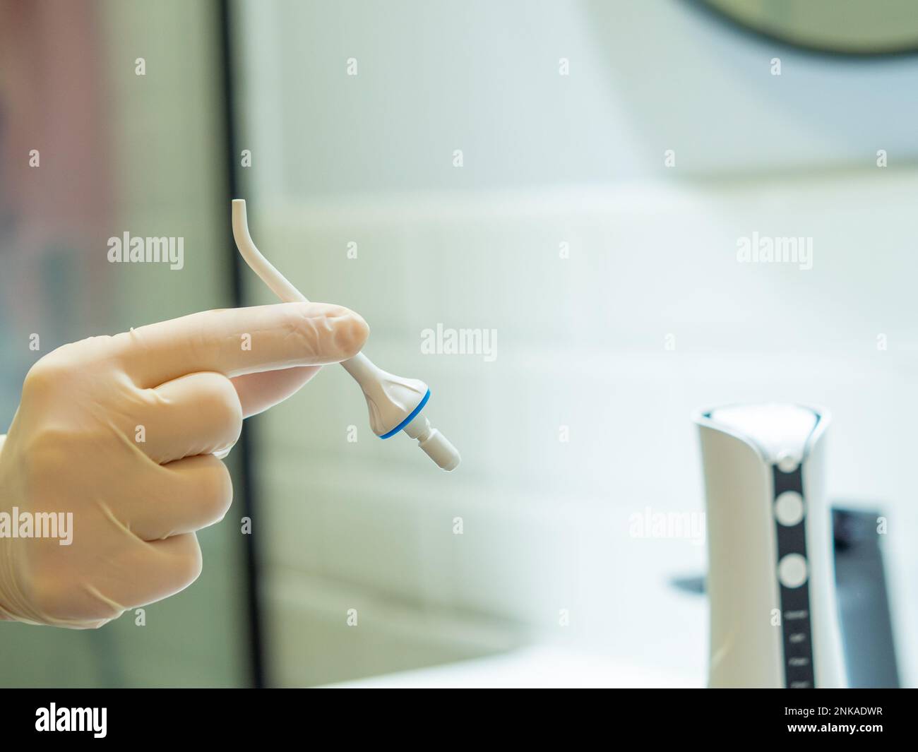 Dentist's hand showing how to use domestic dental water flosser for a