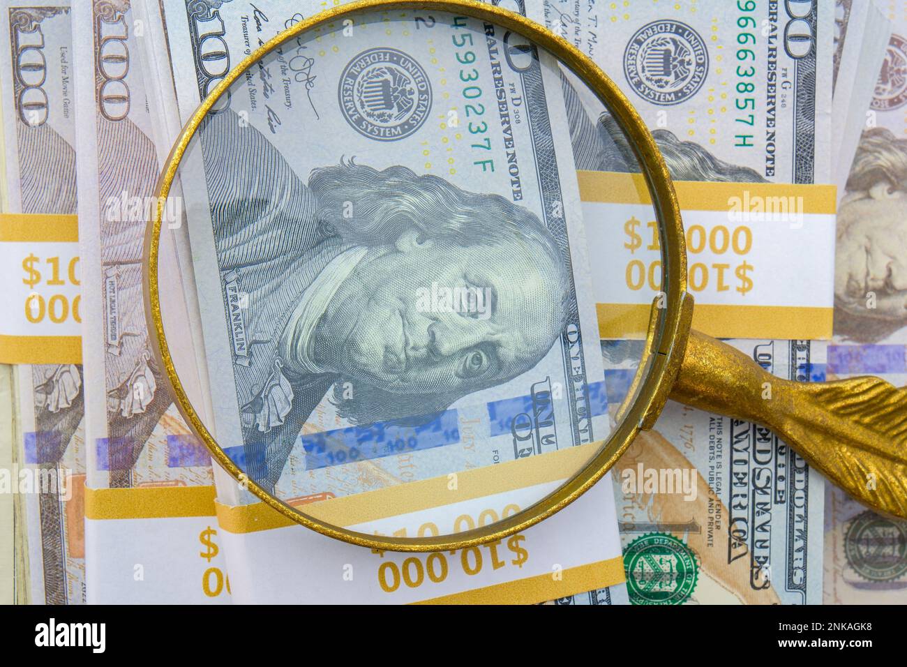 Magnifying Glass Showing Detail Of Hundred Dollar Bills On A Pile Of magnifying-glass-showing-detail-of-hundred-dollar-bills-on-a-pile-of