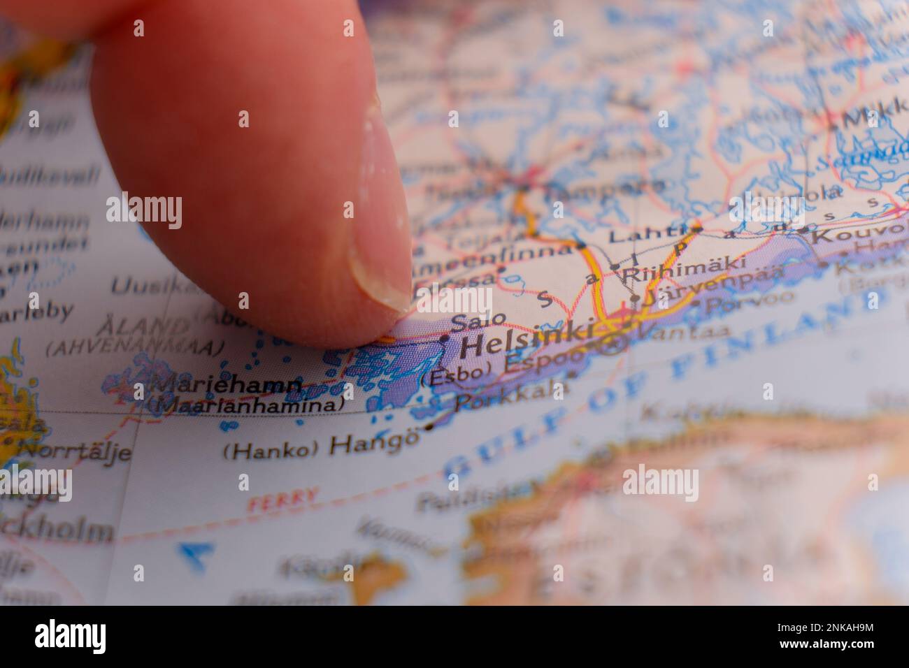 Close up of finger pointing to Helsinki, Finland on colorful map, background blur Stock Photo