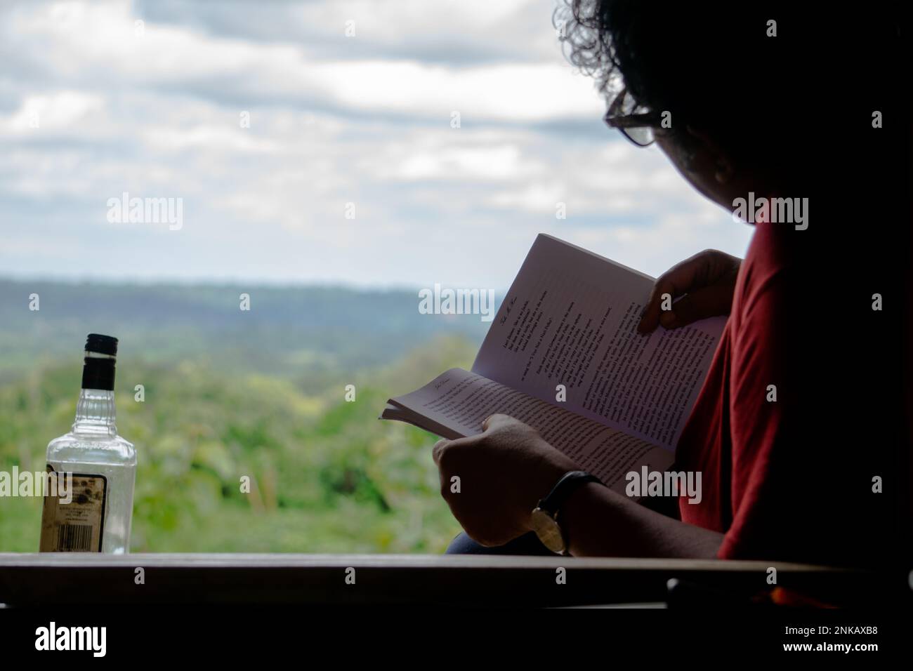 The author is reading a book while sitting in the mountain zoom house. Photo taken from Bandarban, Chittagong, Bangladesh. 8 March, 2022. Stock Photo