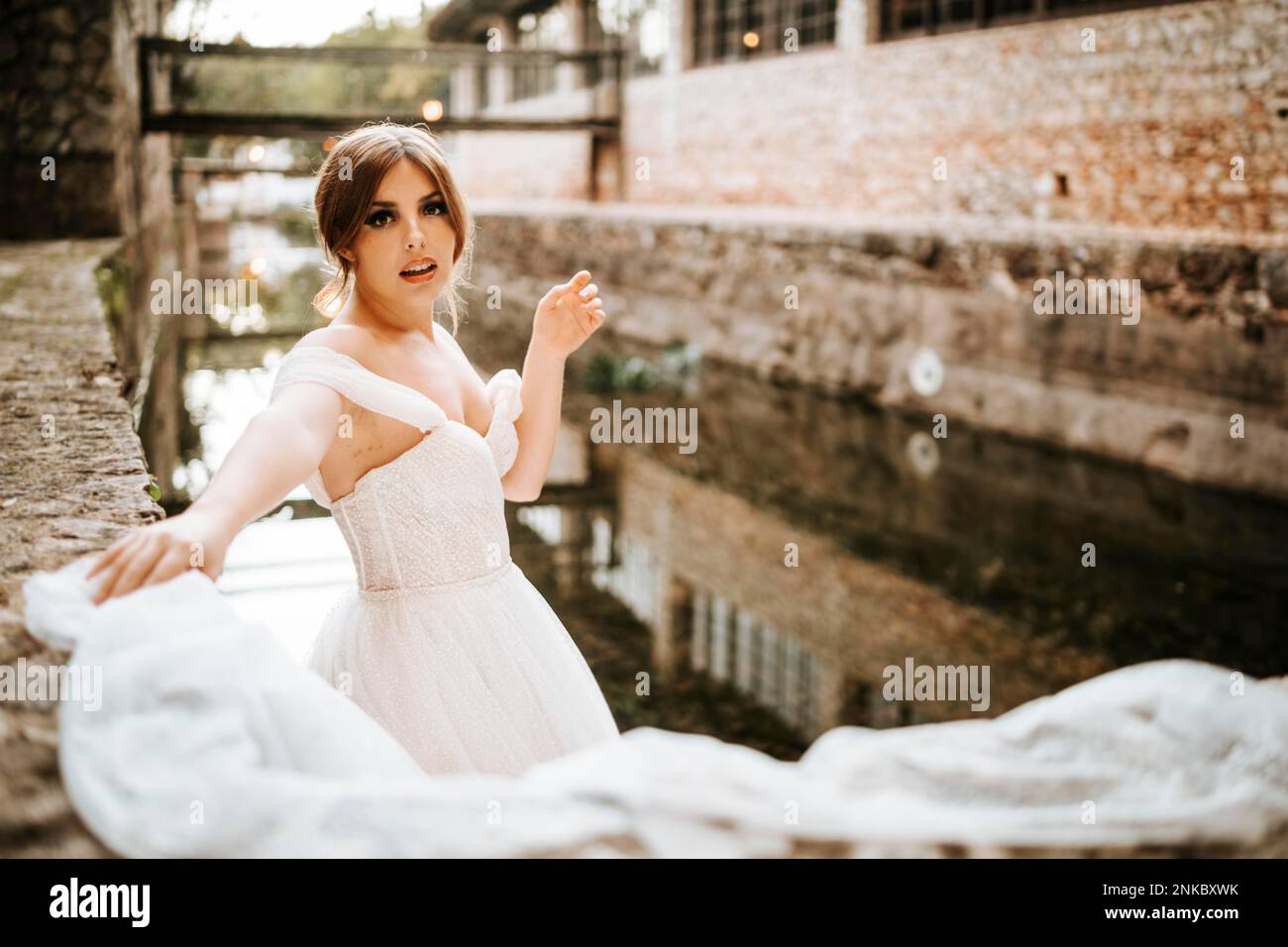 Dreamy portraits of a beautiful bride on stone riverbank Stock Photo