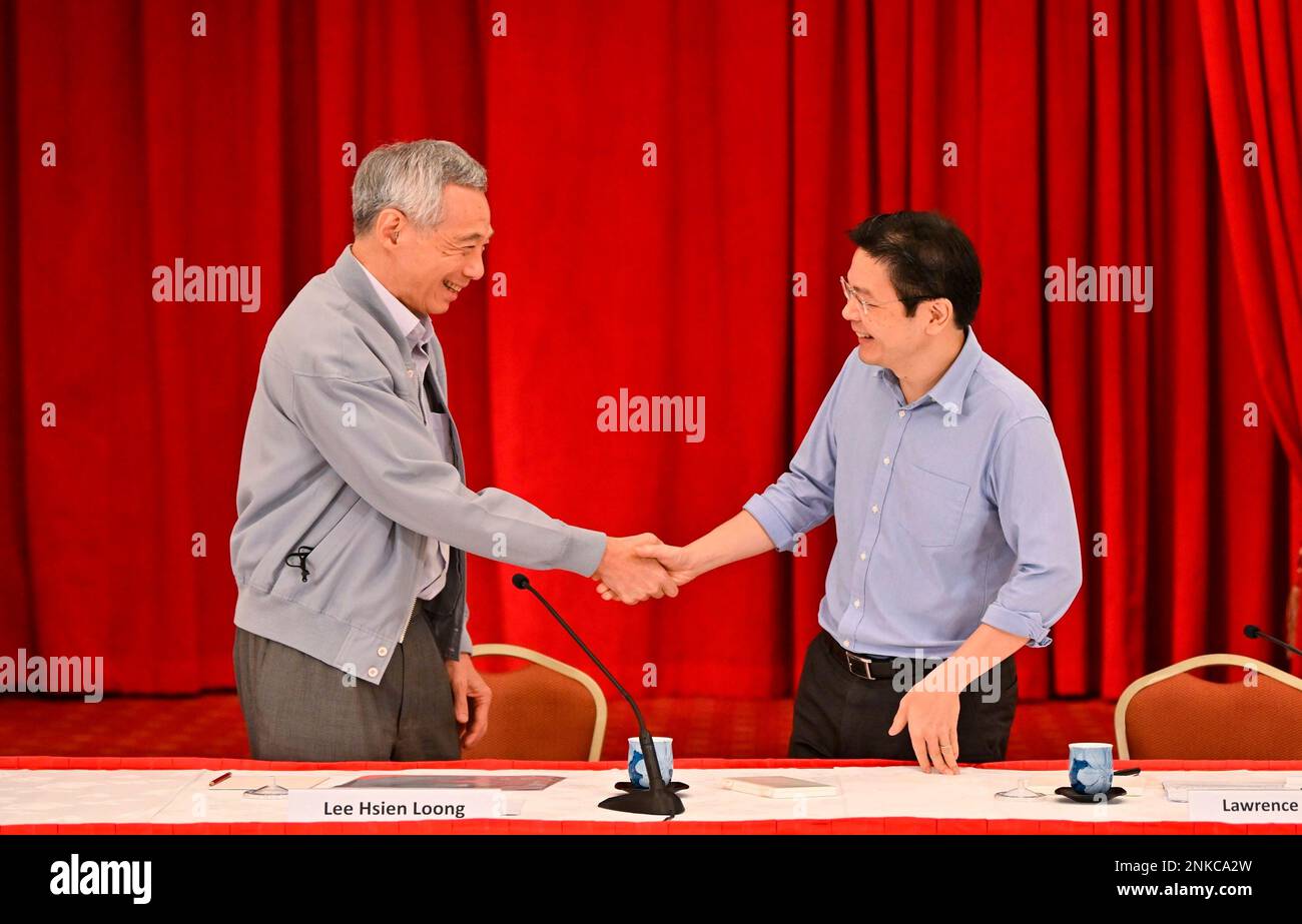 Prime Minister Lee Hsien Loong (left) shaking hands with Finance Minister Lawrence  Wong during a press conference at the Istana on 16 April 2022. PM Lee  announced that Mr Wong was selected