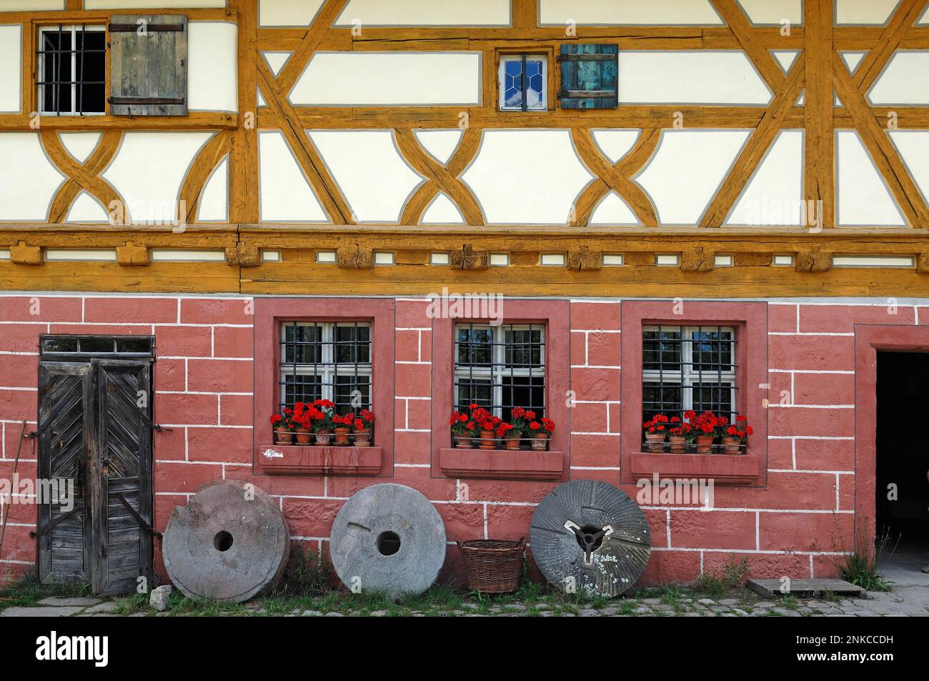 Three millstones in front of the mill, 1575, Franconian Open Air Museum, Bad Windsheim, Middle Franconia, Bavaria, Germany Stock Photo