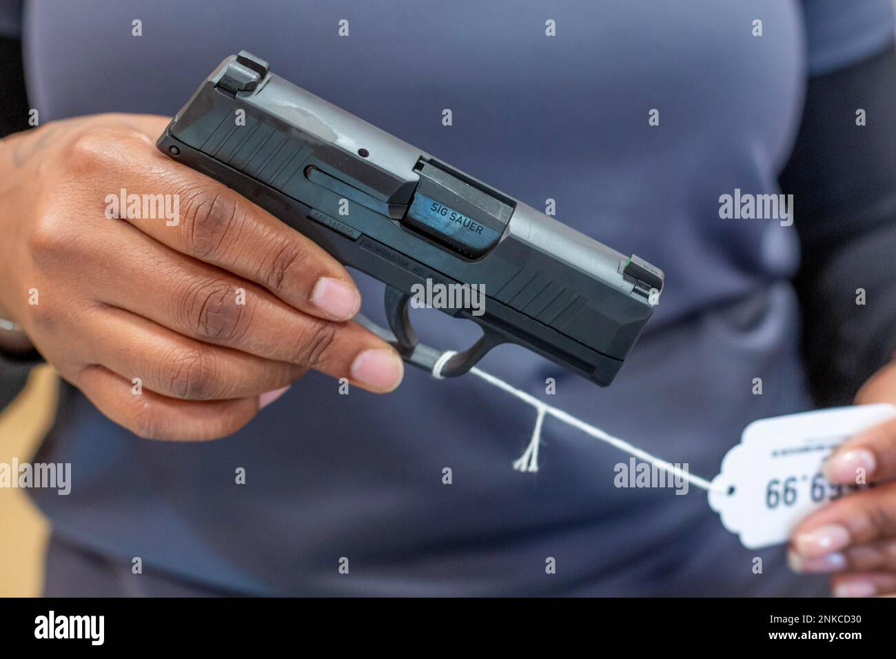 Southgate, Michigan, A saleswoman displays a Sig Sauer pistol at Range