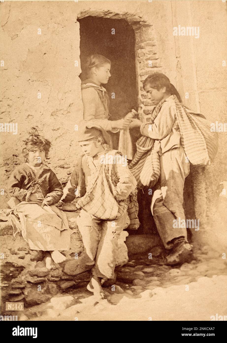 1890 ca., Taormina , Sicily , ITALY : A folkloristic Sicilian studio by photographer GIUSEPPE BRUNO ( 1836 - 1904 ) with little sSicily boys and girl . Bruno was the teacher of celebrated german  photographer Baron WILHELM VON GLOEDEN ( 1856 - 1931 ). The two photographer used not only the same locations but also , like models , the same young boys and girls of Taormina . Usually more of Bruno photos was confused for mistake with some shots by Von Gloeden .  - FOTOGRAFO - FOTOGRAFIA - FOTOGRAPHY  - SICILIA - SICILY - ITALIA - BAMBINO - BAMBINI - BAMBINA - BAMBINE - SCENA DI COSTUME FOLKLORISTI Stock Photo