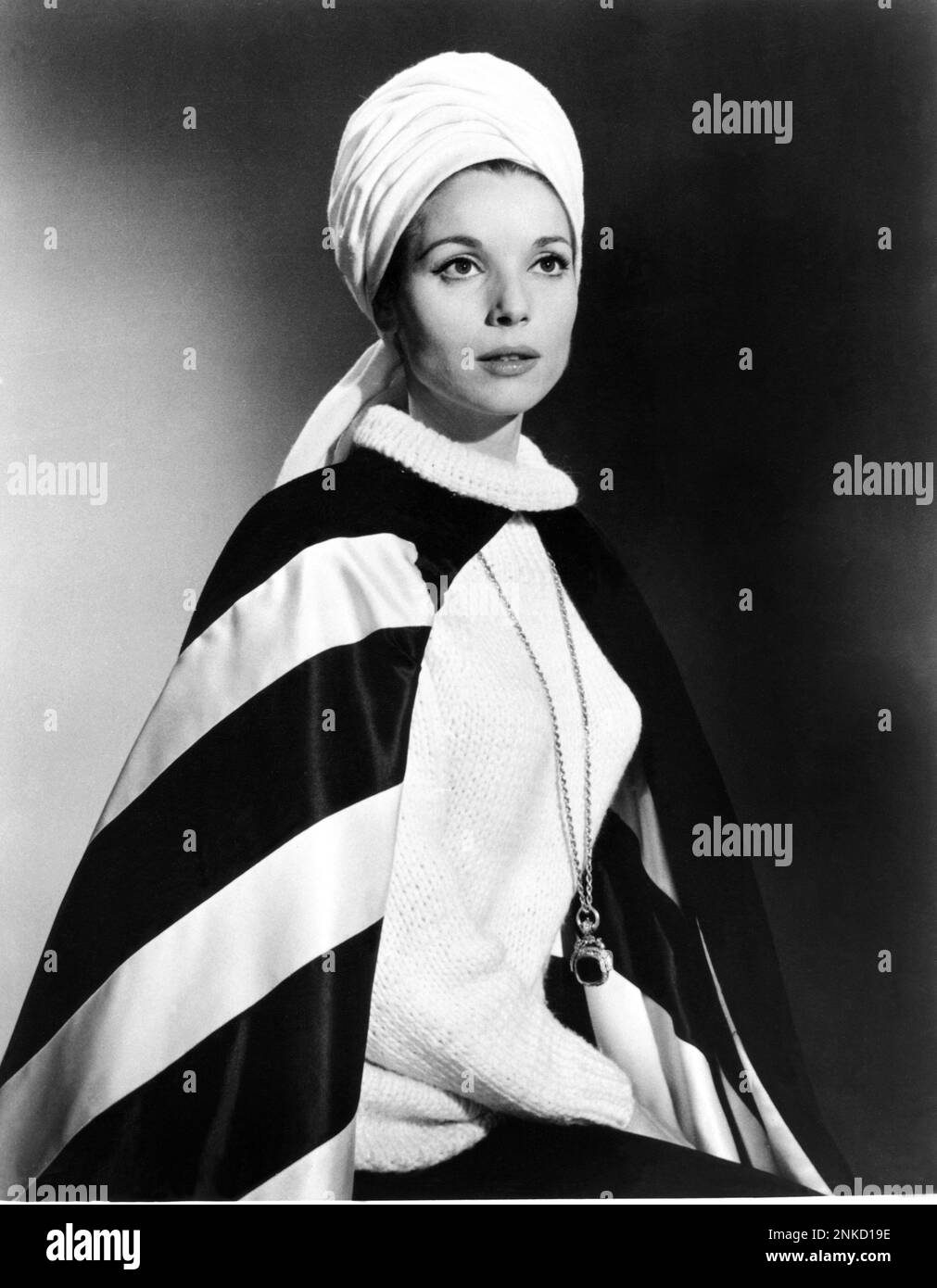 1963 , USA  : The italian actress ELSA MARTINELLI ( born in Rome , Italy , 1935 ) in Hollywood productions , pubblicity still for the movie THE V.I.P.s by Anthony Asquith , writing by Terence Rattingan  - MOVIE - CINEMA - FILM - portrait - ritratto - turbante - turban - maglione di lana - wool - ciondolo - collana - necklace - mantello - coat - jewels - gioiello - gioielli  ----  Archivio GBB Stock Photo