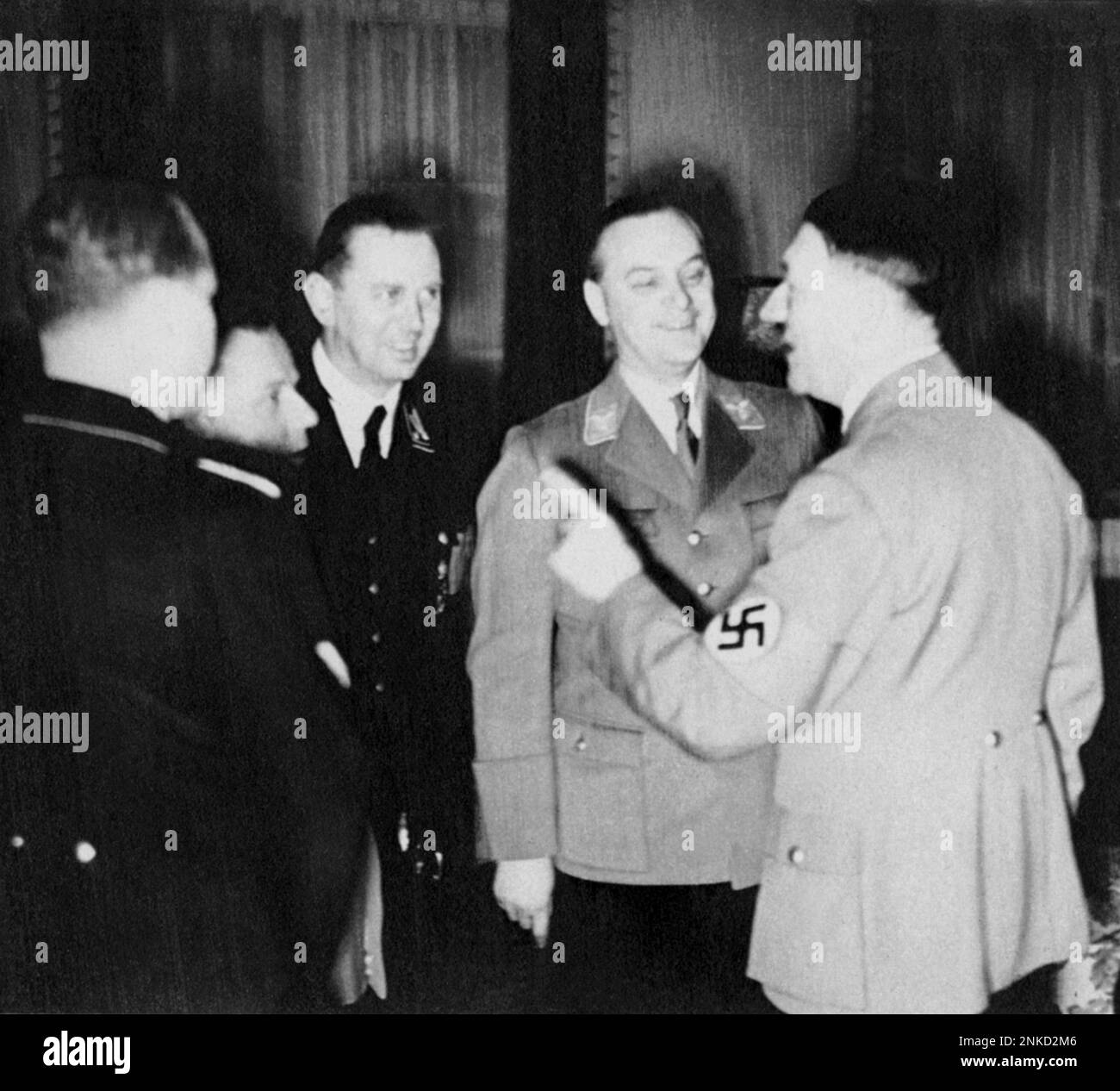 1938 , Berlin , GERMANY  : The german ALFRED ROSENBERG ( 1893 - 1946 ) , in center with gray uniform , at your party for his 45th birthday anniversary with ADOLF HITLER  .Was an early and intellectually influential member of the Nazi Party. He is considered one of the main authors of key Nazi ideological creeds, including its racial theory , persecution of the Jews , abrogation of the Treaty of Versailles  and opposition to ' degenerate ' modern Art . At Nuremberg he was tried, sentenced to death and executed by hanging as a war criminal - WWII - NAZI - NAZIST - SECONDA GUERRA MONDIALE - NAZIS Stock Photo