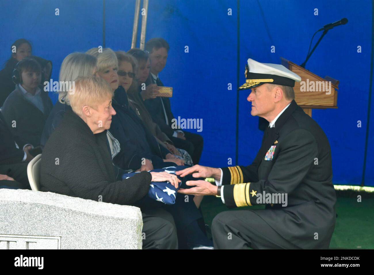 Brenda Lowe accepts a folded American flag from U.S. Navy Rear Adm