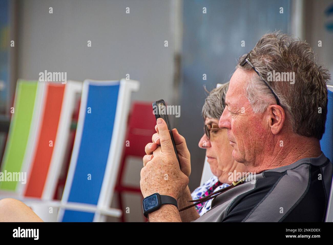 A middle-aged couple with their cell phones, Allure of the Seas, Royal Caribbean cruise lines. Stock Photo