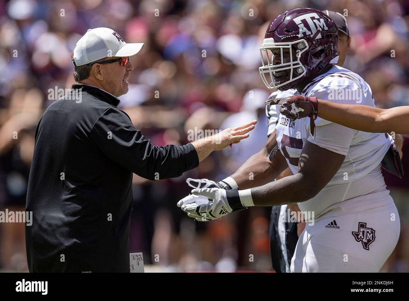 Texas A&M football coach Jimbo Fisher speaks with his players during