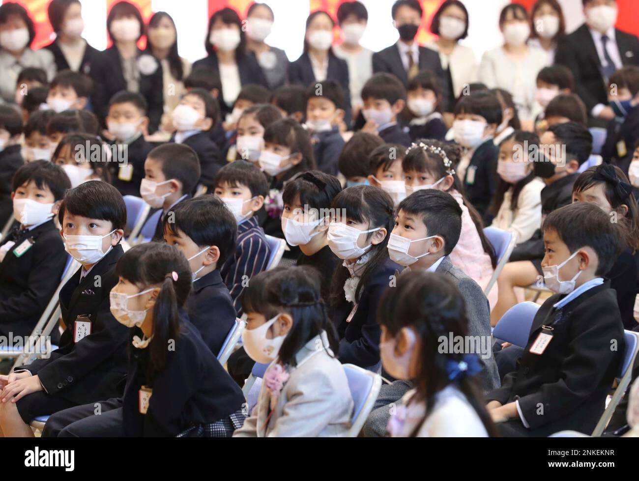 First grade students wearing masks attend an entrance ceremony at