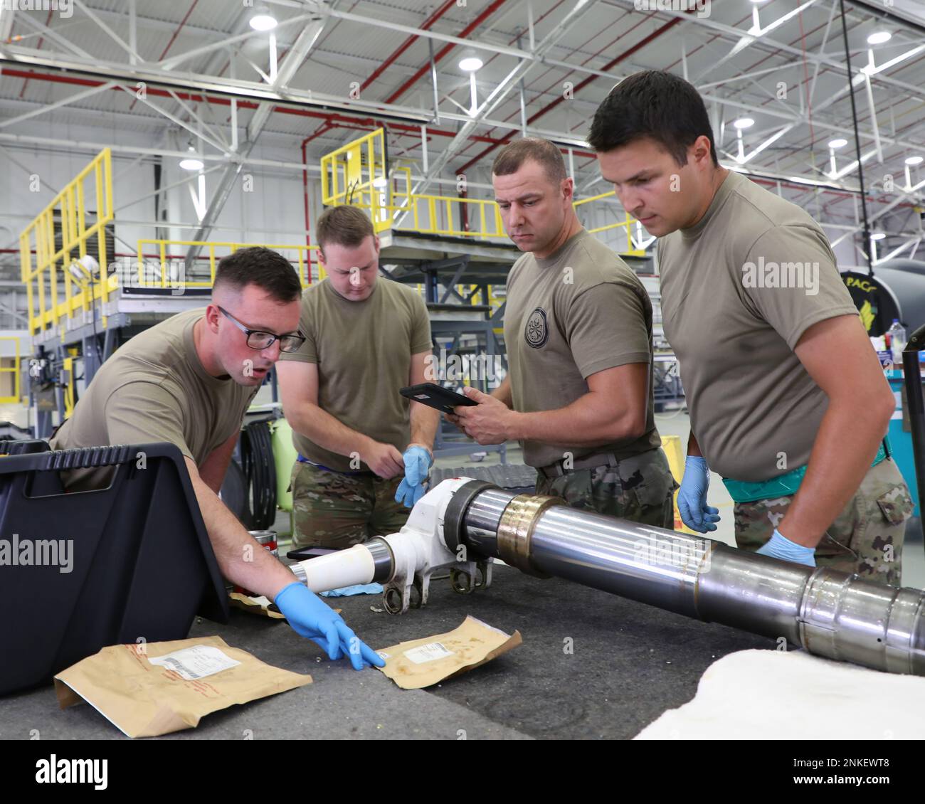 Staff Sgts. Charles Travis, Ryan Grace and Joshua Fye and Airman 1st Class Michael Ritter, work together during maintenance operations on components of a KC-135 Stratotanker at Selfridge Air National Guard Base, Michigan, Aug. 14, 2022. The Airmen are all aircraft hydraulic mechanics, assigned to the 191st Maintenance Squadron at the base. During a scheduled maintenance period on a KC-135, the Airmen removed the front landing gear strut, inspected it for wear and applied new gaskets to the strut. The Airmen utilize technical orders and check each other’s work to ensure that all aircraft compon Stock Photo