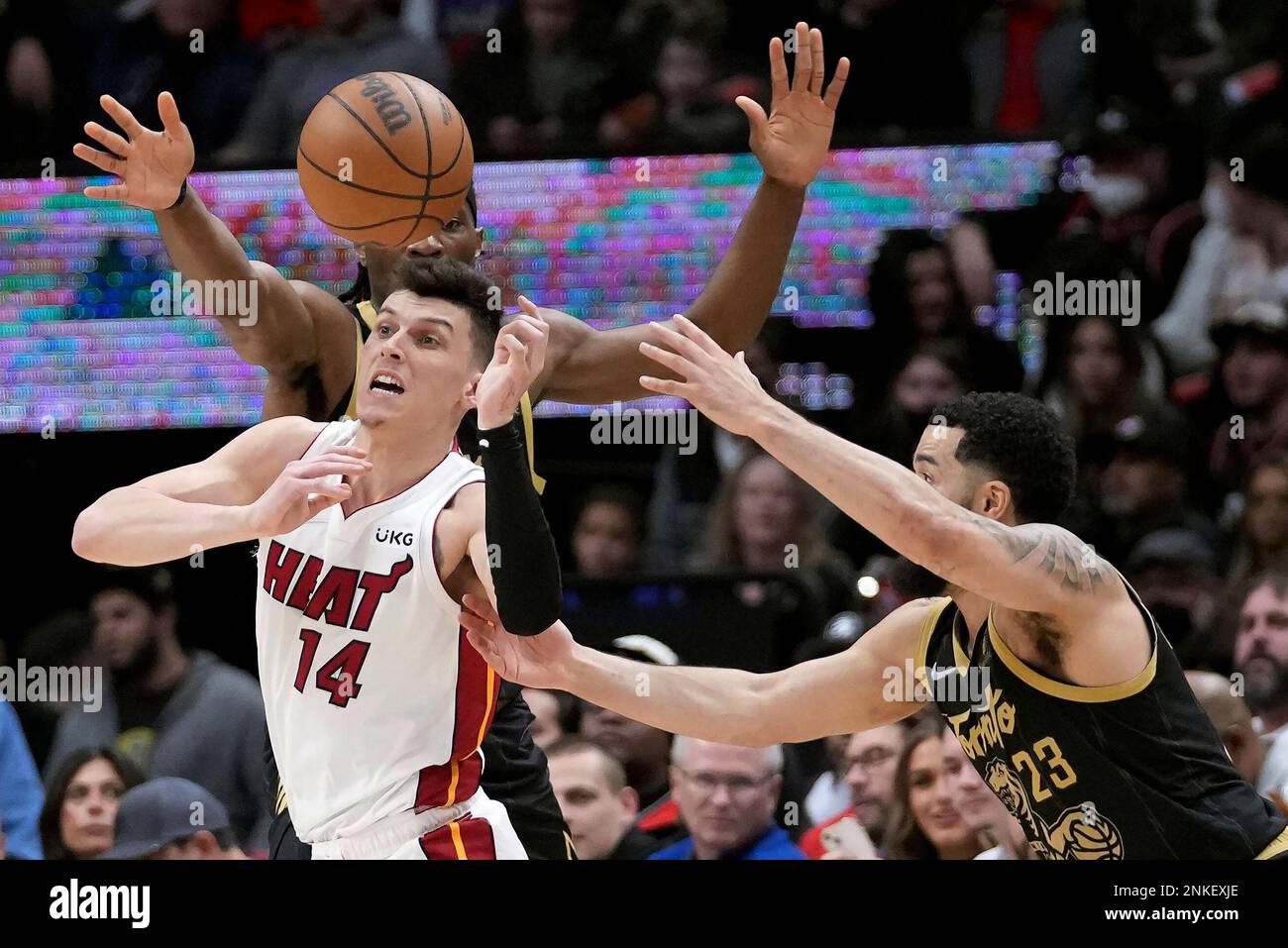 Miami Heat guard Tyler Herro (14) vies for a loose ball with Toronto Raptors' Fred VanVleet (23) and Precious Achiuwa (5) during the first half of an NBA basketball game Sunday, April 3, 2022, in Toronto. (Nathan Denette/The Canadian Press via AP) Stock Photo