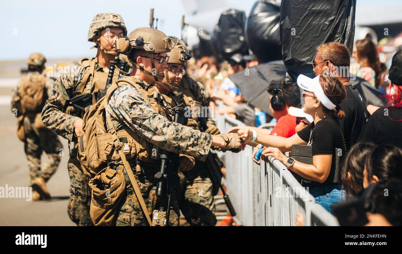 U.S. Marines with 3d Littoral Combat Team, 3d Marine Littoral Regiment, 3d Marine Division, greet families at the 2022 Kaneohe Bay Air Show, Marine Corps Air Station Kaneohe Bay, Marine Corps Base Hawaii, Aug. 14, 2022. The air show was hosted in order for the local community, service members and residents of MCBH to interact during a world-class event. The Kaneohe Bay Air Show, which contained aerial performances, static displays, demonstrations and vendors, was designed to express MCBH’s appreciation to the residents of Hawaii and their continued support of the installation. Stock Photo