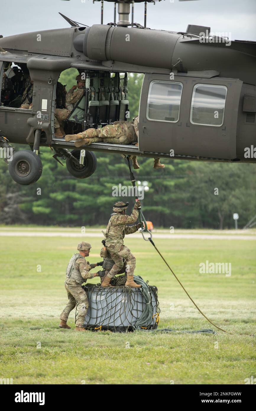 U.S. Army Soldiers, 237th Brigade Support Battalion, Cleveland, Ohio, attach a cable during a sling load mission at the Camp Grayling Parade Field, Grayling, Mich., Aug 14, 2022 during exercise Northern Strike 22-2. Northern Strike is designed to challenge approximately 7,400 service members with multiple forms of training that advance interoperability across multicomponent, multinational and interagency partners. Stock Photo