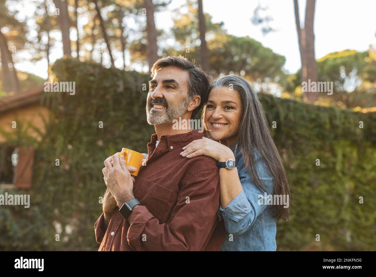 Happy affectionate mature couple standing outside building Stock Photo