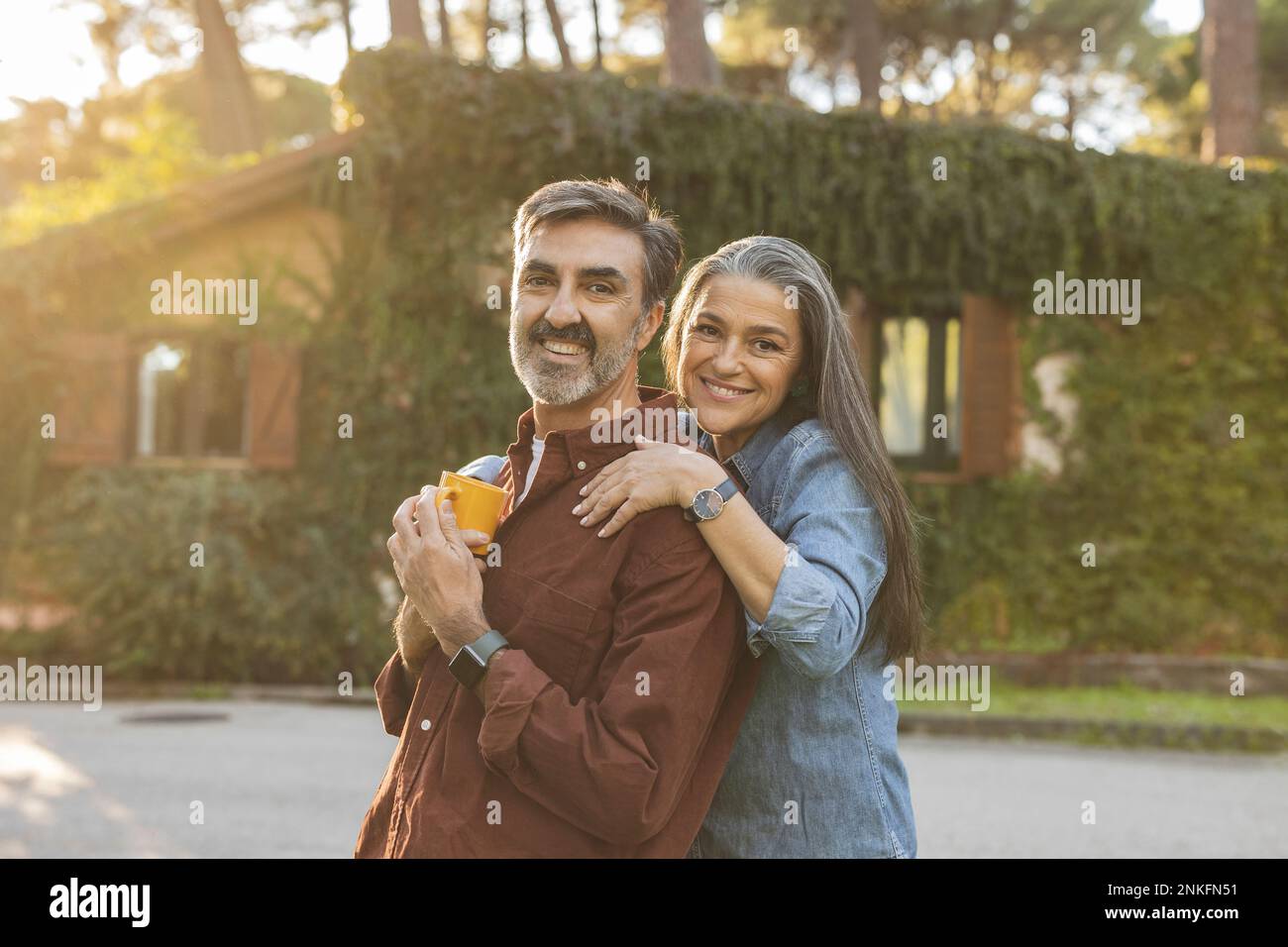 Happy affectionate mature couple standing outside building Stock Photo