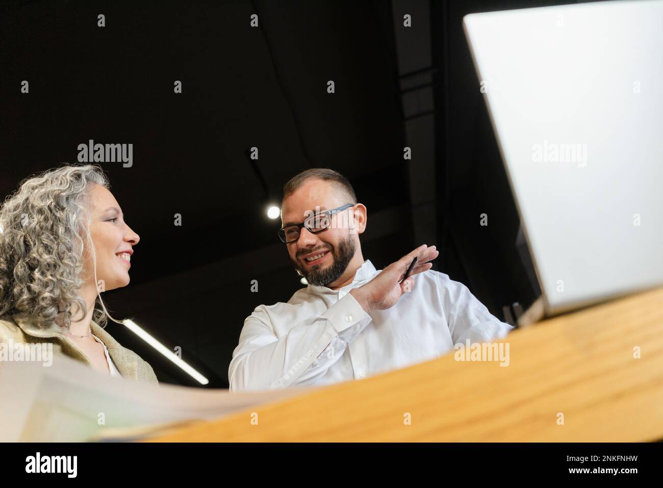 Two smiling colleagues working together in office Stock Photo