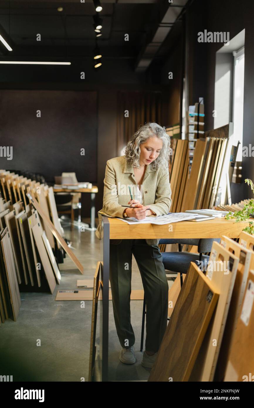 Female architect working at table in office Stock Photo