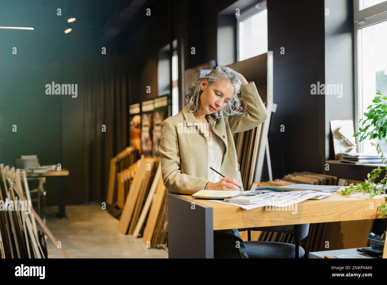 Female architect working at table in office Stock Photo