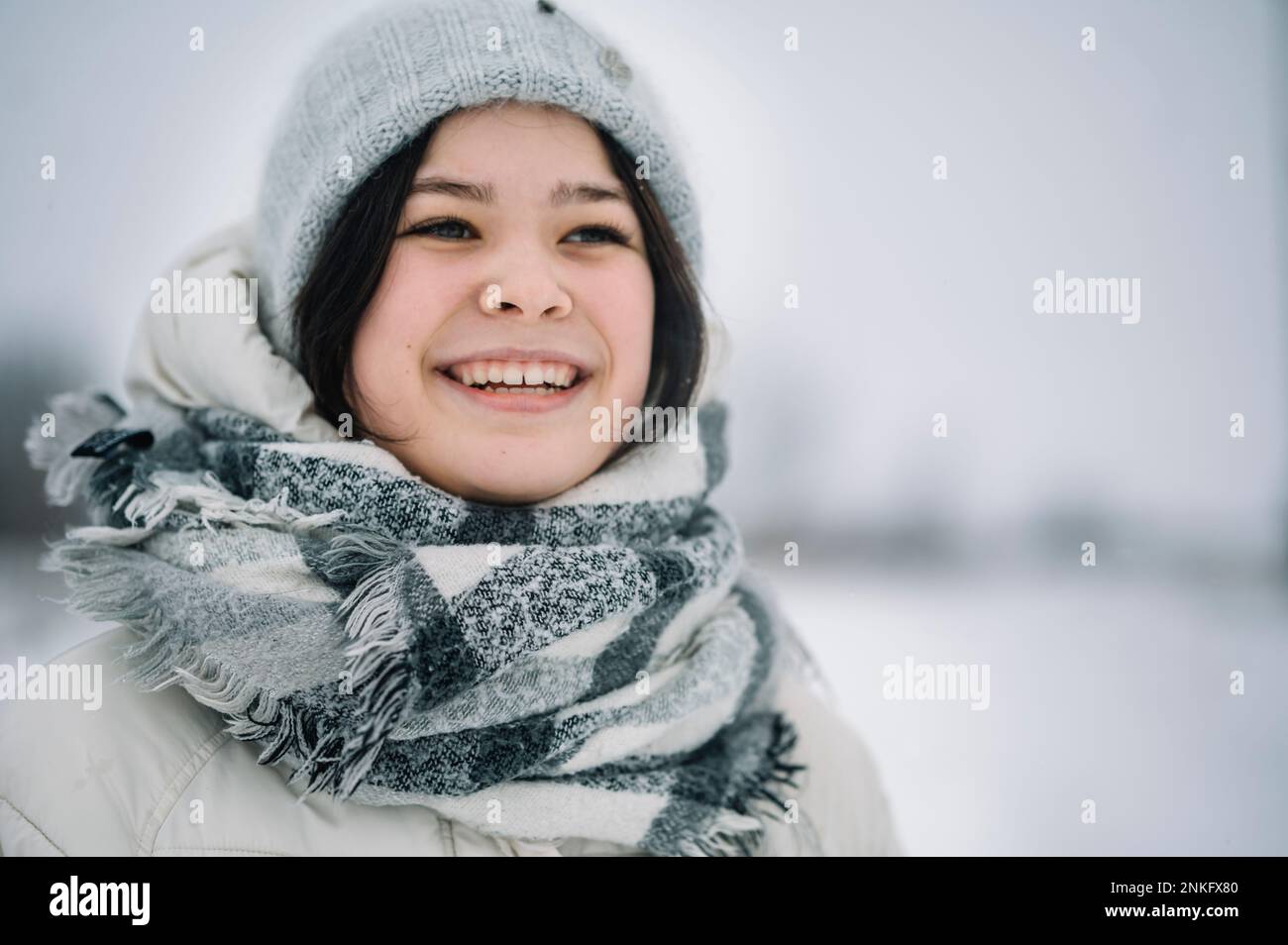 Happy girl wearing scarf and knit hat Stock Photo