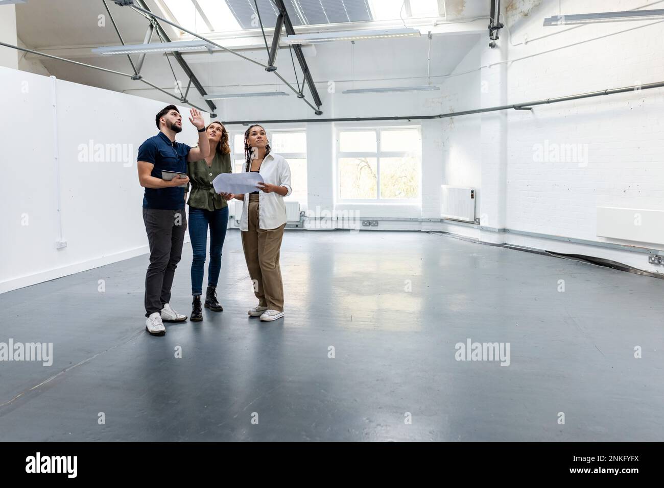Young businessman planning with colleagues in empty space Stock Photo ...