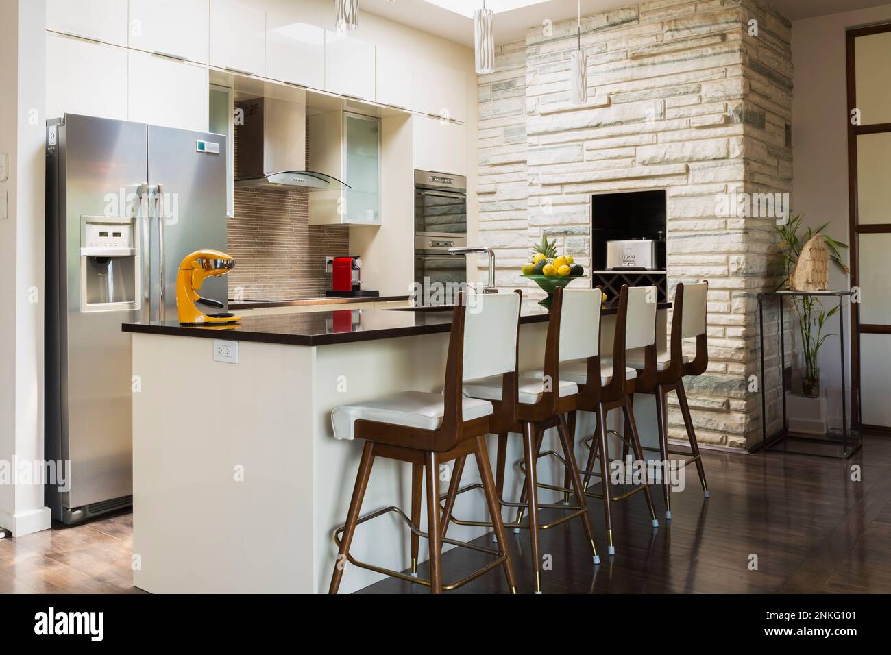 Kitchen with white lacquered wooden cabinets, island with quartz